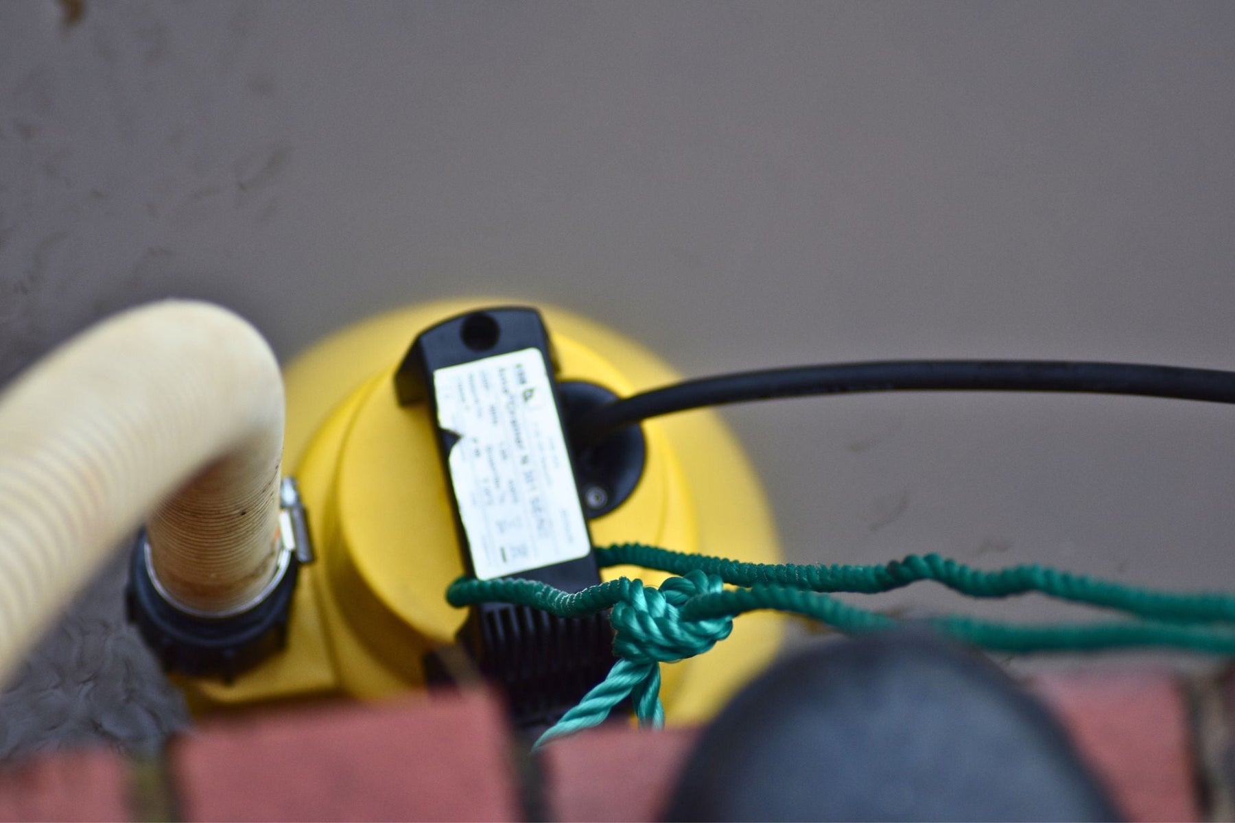 Flooded Basement Pictured with automatic water pump and hose