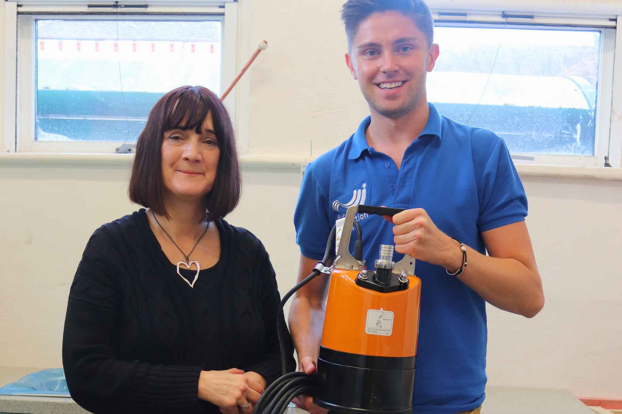 Mary Dhonau with Simon Crowther and Tsurumi LSC puddle pump in a kitchen