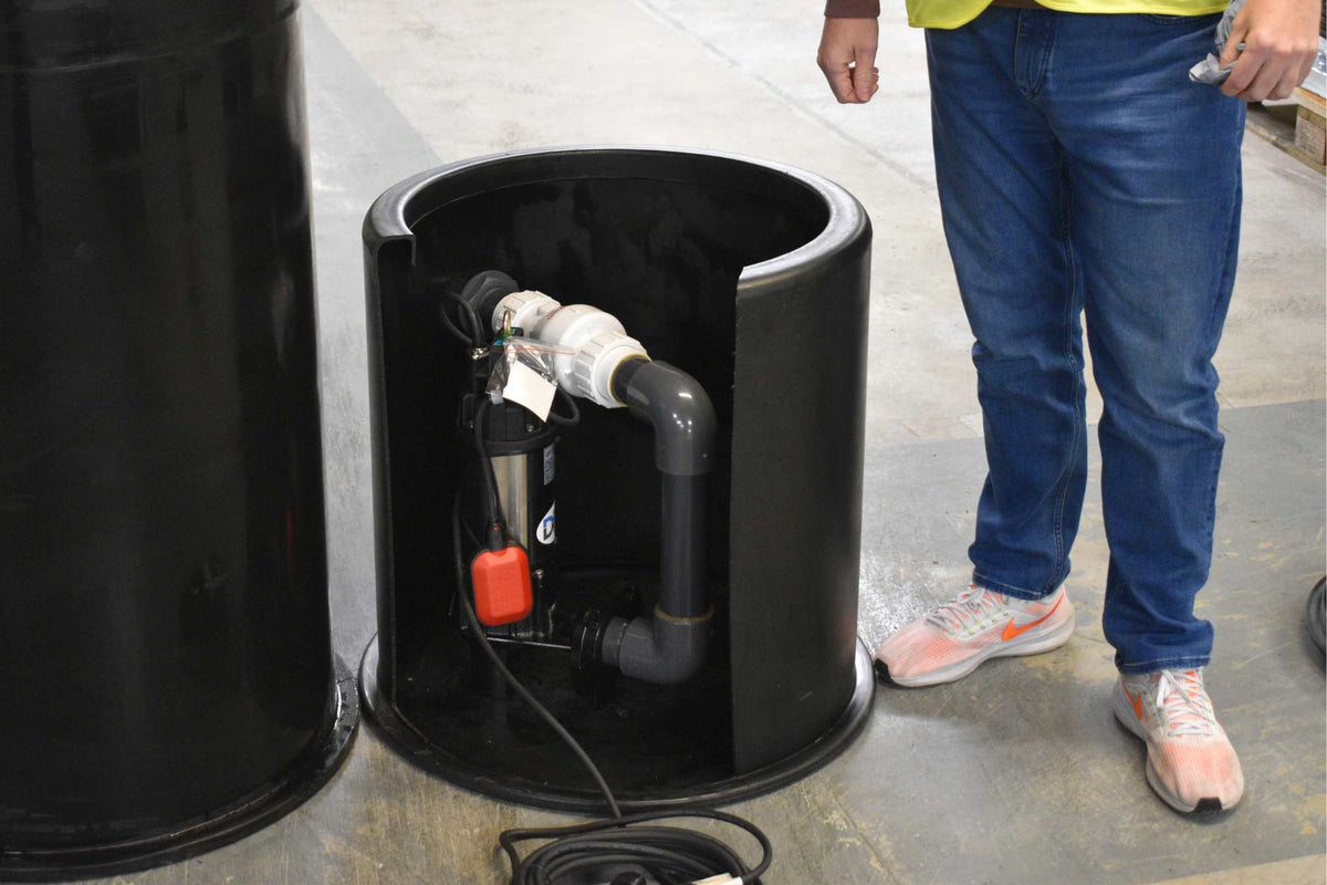 Man stood next to sump pump chamber assessing suitability