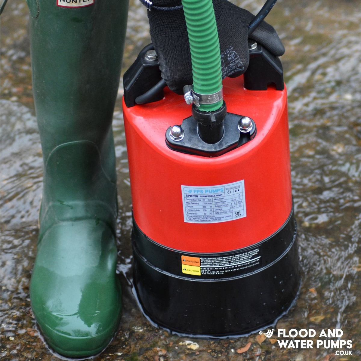 Man in hunter wellingtons with water pump