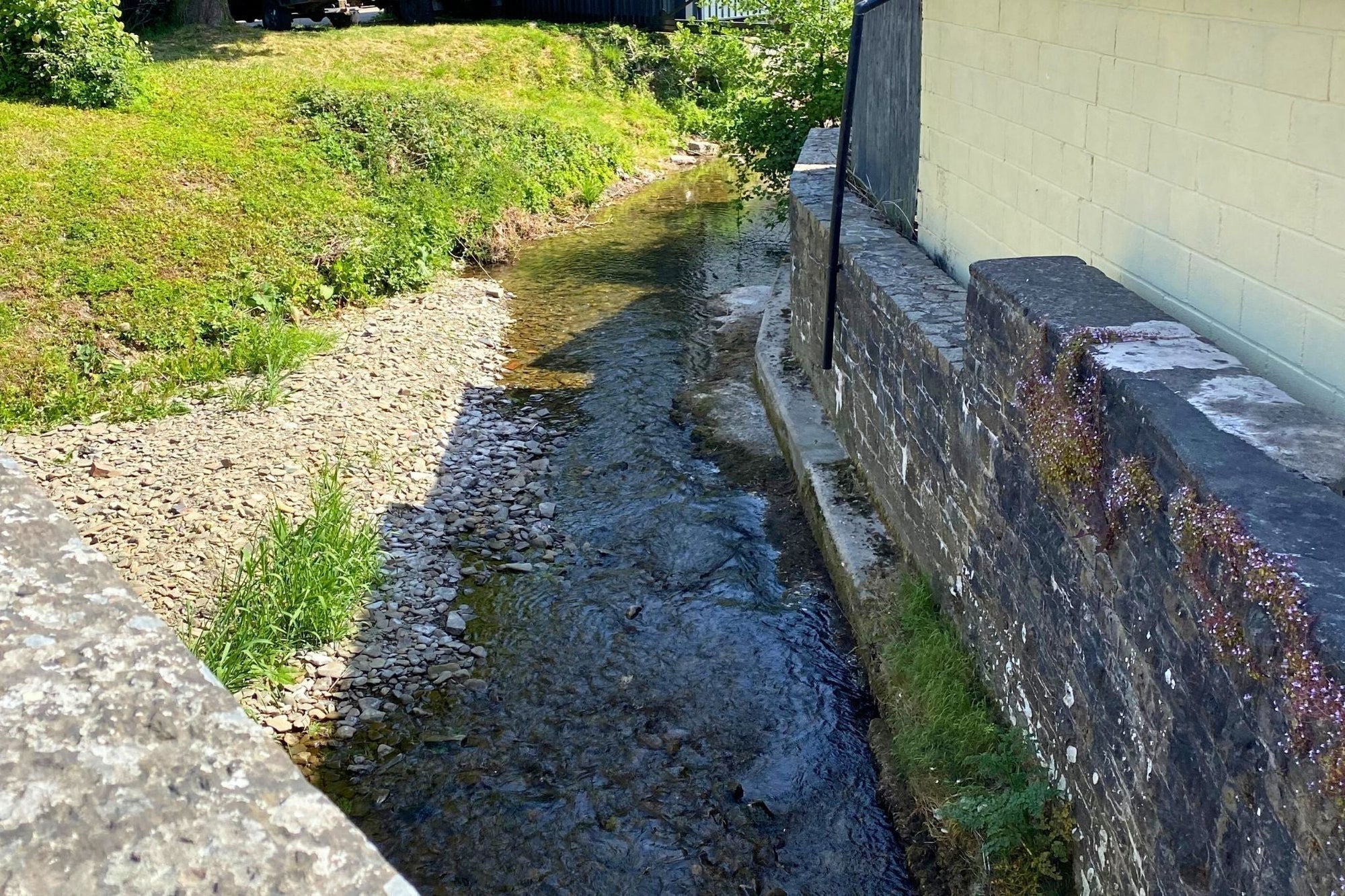 Riverbank pictured with wall to one side