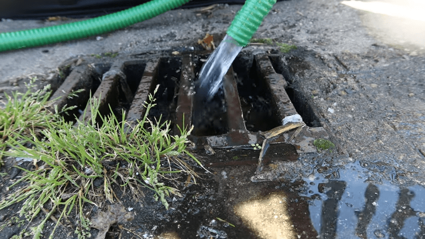 water flowing out of pump hose into drain