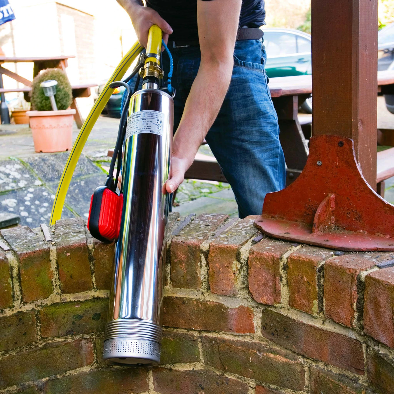 Eurojet well and borehole pump shown being placed into a well to pump water via a hose
