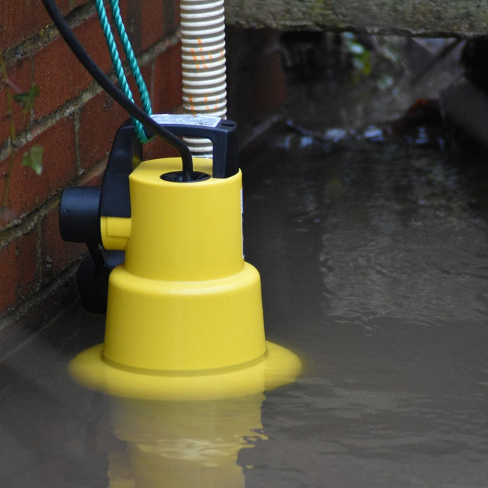 automatic submersible pump in flood water next to a brick sump chamber
