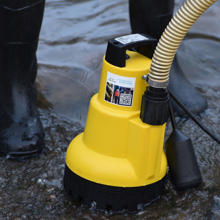 AMA Drainer Automatic Submersible Water Pump in water with a person wearing rubber boots in the background