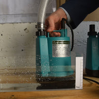 Hand holding the APP BPS small puddle pump with clear braided hose. 