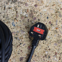 230V Electrical plug on a textured concrete surface