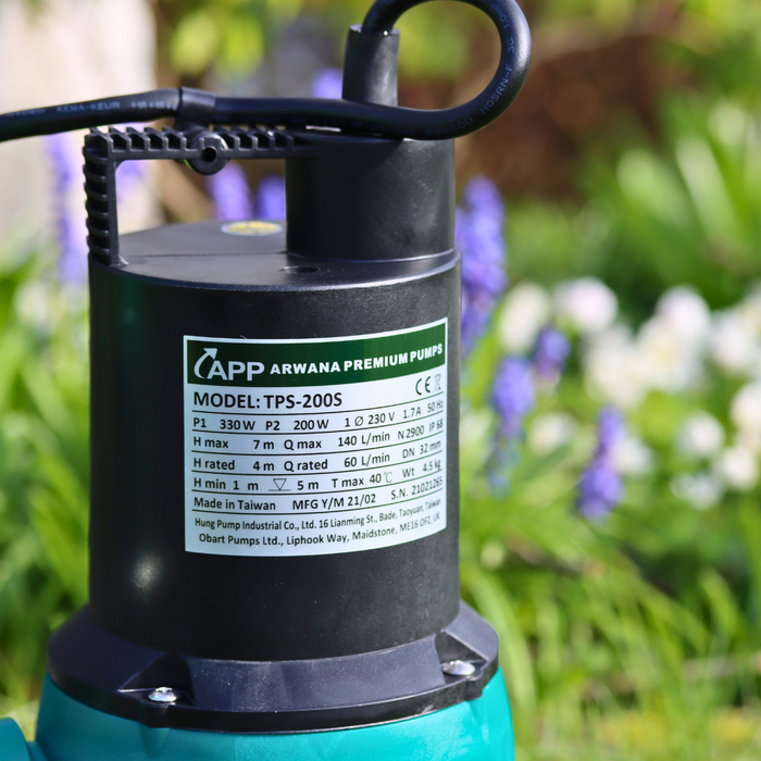 Close up of TPS pond pump with technical label infront of wild flowers