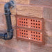 two terracotta anti flood air brick set into a brick wall