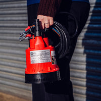 Compact 12V Baby Battery Water Pump held by woman, lightweight and portable for effortless water transfer.