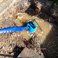 Contractor pump installed in an excavated dirt pit with dirty water