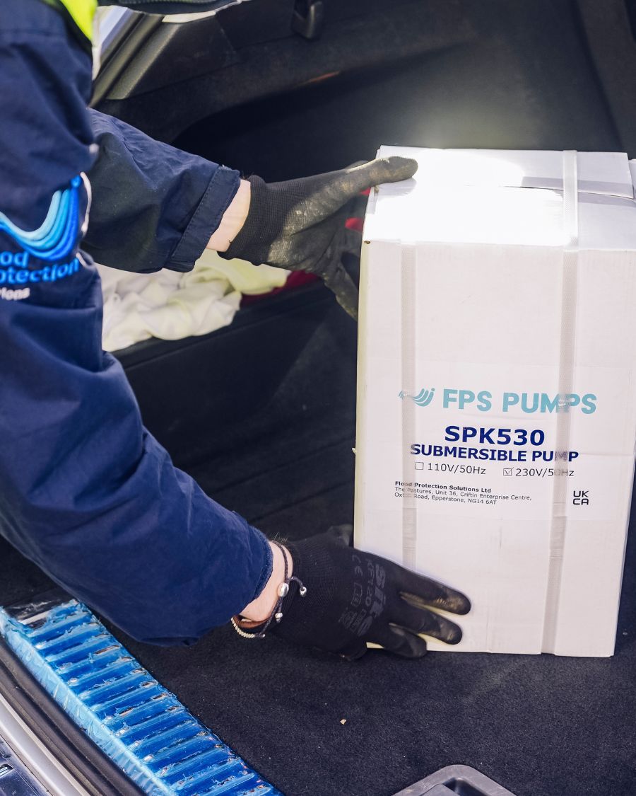 A person loading an FPS Pumps box into a car