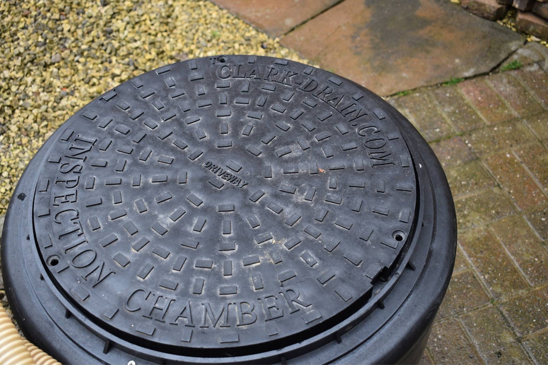 Manhole cover with 'Inspection Chamber' text on a pavement background