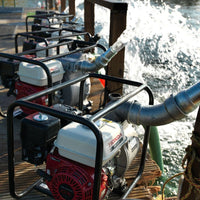 Honda water pumps on a dock with water flowing from them.