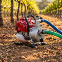 Red Honda engine pump with hoses in a vineyard setting


