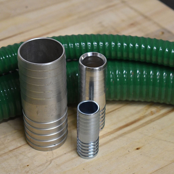 Three metal hose pipe joiners with green suction and delivery hose in the background.