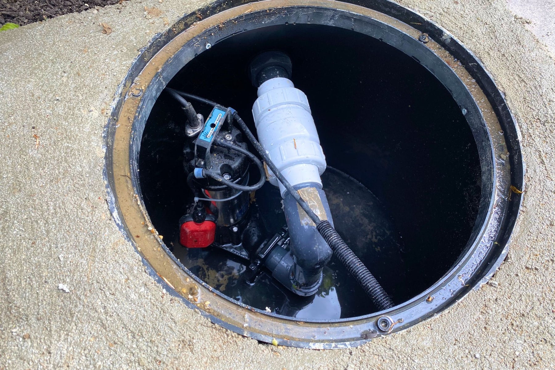 Pump inside a manhole cover on a concrete surface