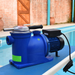 Blue pool pump on a pool deck with brick wall background