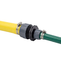 A close-up of a garden hose connector showing a yellow hose, a black threaded fitting, and a green patterned hose secured with metal clamps on a white background.