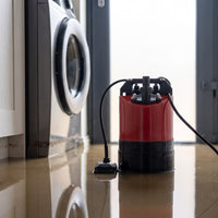 Automatic puddle pump with floor sensor next to a washing machine in a flooded laundry room setting.