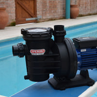 Speroni swimm 2000 swimming pool pump on a pool side with brick wall and pots in the background