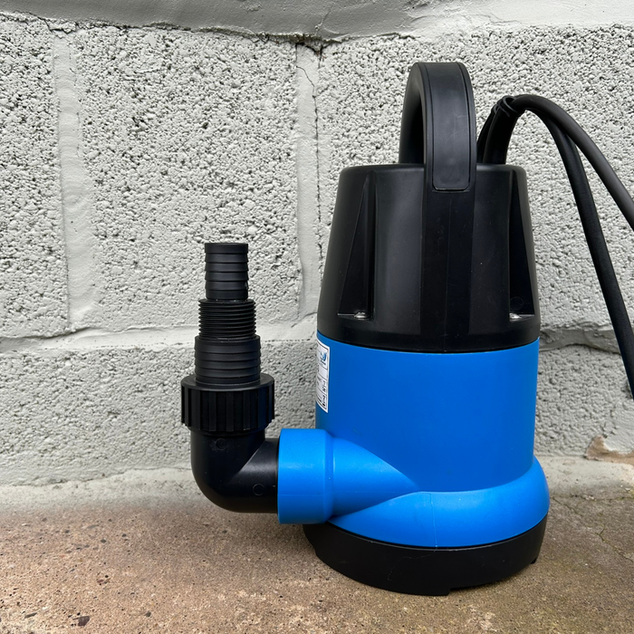Blue and black submersible pump against a concrete wall.