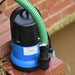 submersible pump with Spa 250 label a green hose attached, on a brick surface.