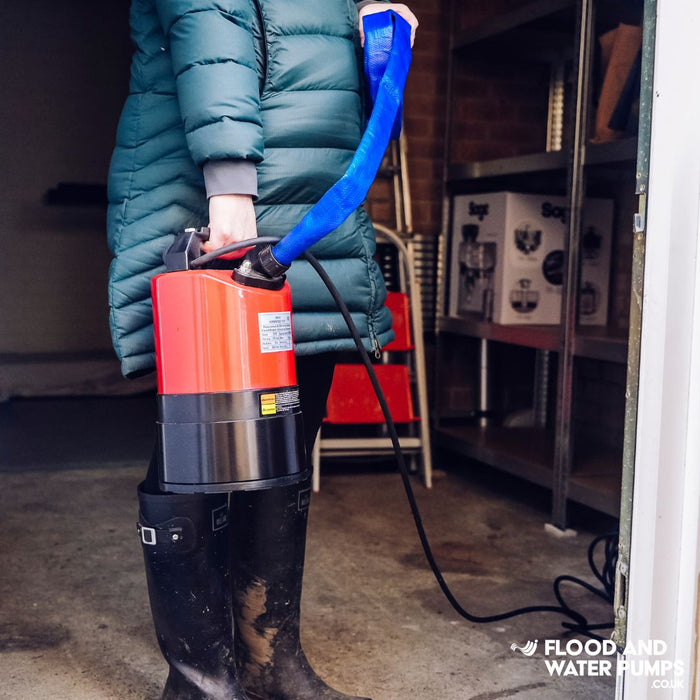 Stream SPK530 Red Puddle Pump held by a woman, showcasing its compact and lightweight design for efficient water removal.