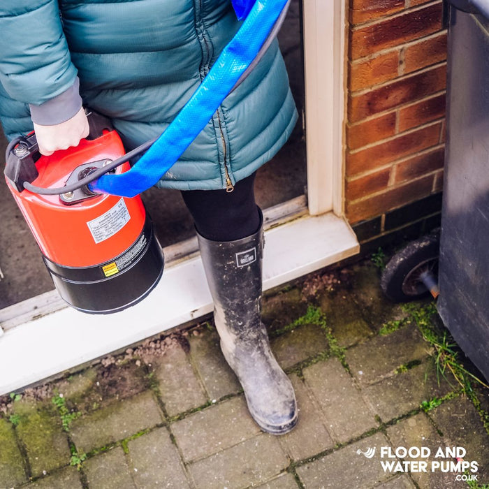 Stream SPK530 submersible Puddle Pump carried by a woman, emphasizing its robust and durable construction for tough water removal tasks.