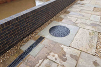 A pump station and drain installed next to a flood wall