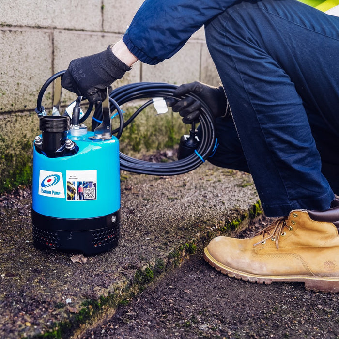 Tsurumi LB Submersible Pump, Compact and durable pump for efficient water removal in tough environments, pictured with man.