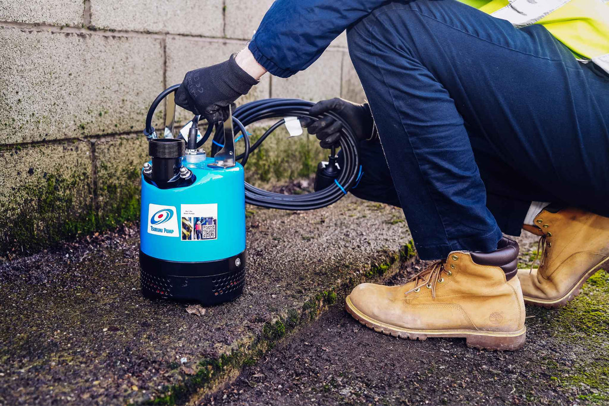 Tsurumi submersible site pump being set up on a wet gravel site
