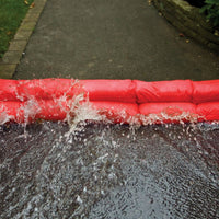 Red hydro snake flood barrier on a driveway